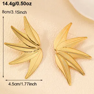 Detaillierte Nahaufnahme goldener Blatt-Ohrringe mit feiner Metallstruktur und tollem Design.