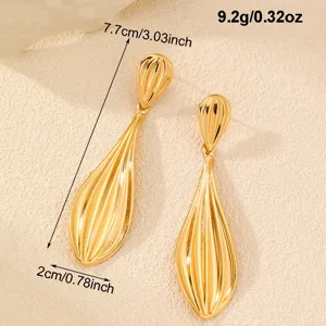 Goldene metallische Tropfen-Ohrringe Detail, modernes Blatt-Design Schmuck Nahaufnahme.