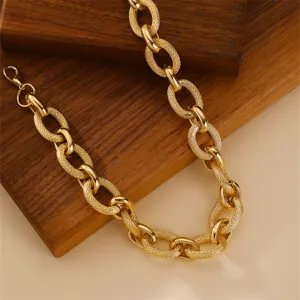 Chunky gold chain necklace detail shot featuring textured interlocking links and lobster clasp.