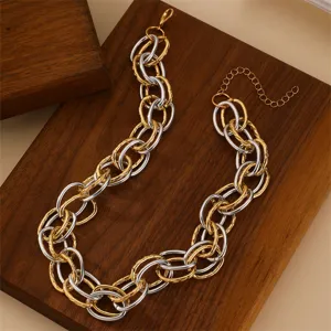 Detail shot of a bold two-tone chunky chain necklace, interlocking gold and silver links.