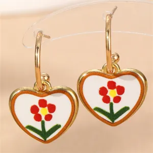 Nahaufnahme stilvoller geometrischer Herzohrenringe mit buntem Blumen-Emaildesign für Damen.