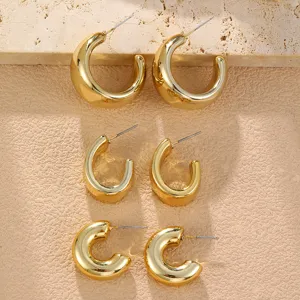 Detailansicht des klobigen goldenen Creolen-Sets mit minimalistischen C-förmigen Designs.