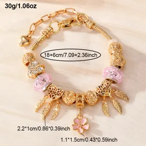 Vergoldetes DIY Charm Armband Detail mit rosa Perlen, Herzanhängern und Blumenanhänger.