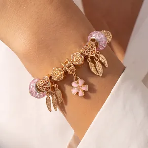Vergoldetes DIY Bettelarmband mit rosa Kugelperlen und Herz Feder Anhängern für Damen.