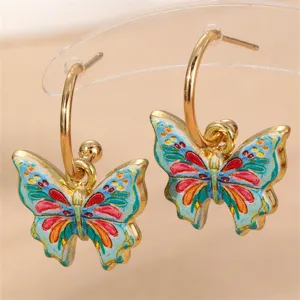 Goldene Creolen mit bunten Emaille-Schmetterlingsanhängern, modischer Damenschmuck.