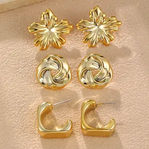 Goldene Ohrringe Set Detail mit stilvollen Blumen, verknüpften Knoten und C-Creolen, Modeschmuck.
