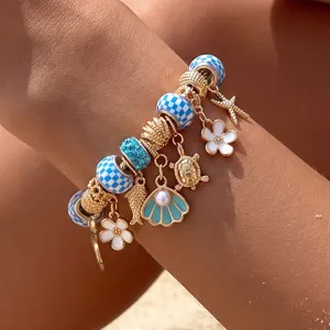 Nahaufnahme eines Sommer-Strand-Charm-Armbands mit blauen Karoperlen und Meeresanhängern.