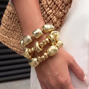 Nahaufnahme von unregelmäßigen Metallperlen Armbändern im Vintage Gold Stil, Statement Schmuck.