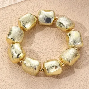 Nahaufnahme des Vintage goldenen unregelmäßigen geometrischen Perlenarmbands mit Textur.
