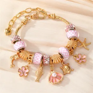 Goldfarbenes Charm-Armband mit rosa Karoperlen und schönen Meeresanhängern für Damen.