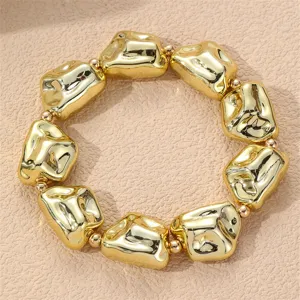 Nahaufnahme des unregelmäßigen goldenen geometrischen Perlenarmbands mit glänzender Metallstruktur.
