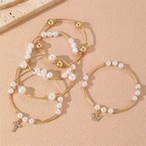 Conjunto de pulseras de perlas doradas en capas con dijes de cruz y corona elegante