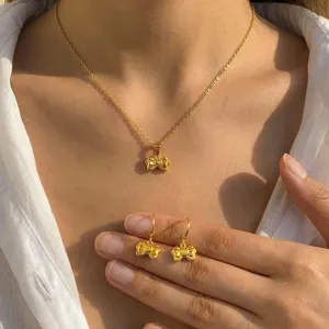Nahaufnahme Detailansicht der goldenen Edelstahl Herz Schleife Halskette und Ohrringe Schmuck.