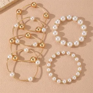 Elegante juego de pulseras apilables de alambre dorado y perlas, joyería fina para mujer.