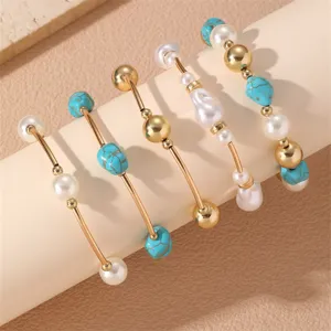 Elegante juego de pulseras apilables con cuentas doradas, perlas artificiales y turquesa.