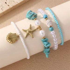 Boho βραχιόλι πολλαπλών στρώσεων με αστερία κοχύλι τιρκουάζ μαργαριτάρι κοντινό.