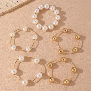 Conjunto de pulseras en capas con perlas blancas y cuentas doradas joyería.