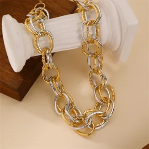Close-up detail of chunky gold and silver interlocking O-chain necklace, hip-hop style design.