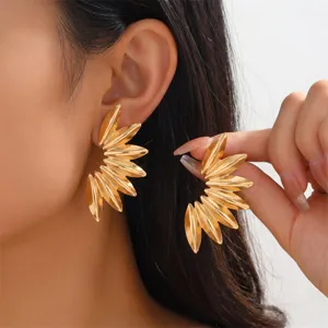 Nahaufnahme von stilvollen goldenen Blatt Metall Ohrringen, schickes Modeaccessoire.