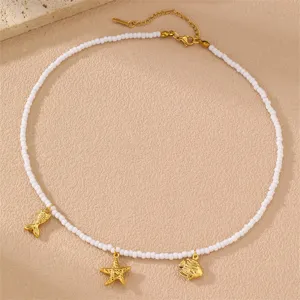 Detailansicht der goldenen Perlenkette mit Ozean Seestern und Fisch Anhängern Strandstil.
