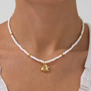Goldfisch Anhänger Choker Halskette mit weißen Perlen und goldenen Abstandsperlen Akzenten.