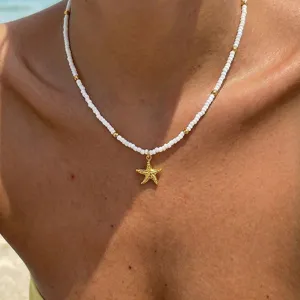 Weißes Perlenketten-Collier mit goldenen Abstandshaltern und strukturiertem Seestern-Anhänger.