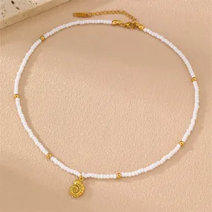 Zarte weiße Perlenkette mit goldenem Muschelanhänger und praktischer Verlängerungskette.