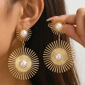 Detailansicht von goldenen Sonnenstrahl Ohrhängern mit Perle für stilvolle Damen Mode.