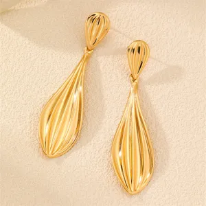 Nahaufnahme der trendigen goldenen tropfenförmigen Ohrringe, elegante Blattstruktur.