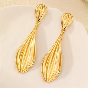 Detailaufnahme eleganter goldener Ohrringe mit geripptem Blatt-Design und glänzendem Finish.