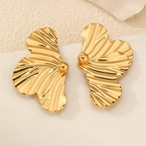 Nahaufnahme von goldenen Metall Ginkgoblatt Ohrringen mit runder Kugel Detailverzierung.
