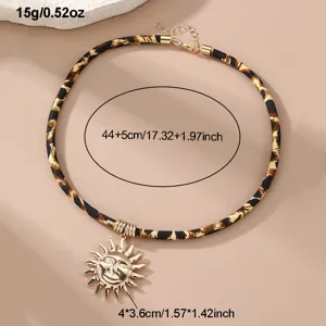 Nahaufnahme Detail der Leo-Print Samtseil Kette mit goldenem Sonnen Anhänger Schmuck.