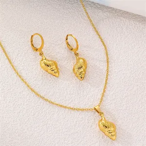 Goldfarbenes Edelstahlschmuck-Set mit Muschel-Anhänger, Halskette und Ohrringen im Detail.