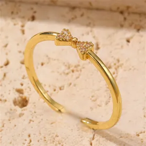 Goldener offener Ring Detail Nahaufnahme mit glitzerndem Zirkonia Schleife Akzent Design.