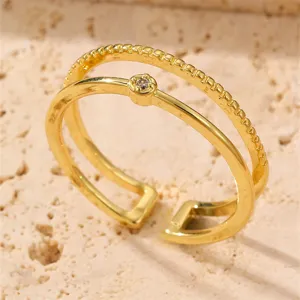 Nahaufnahme eines stilvollen doppelten Goldrings mit einem kleinen funkelnden Zirkon.