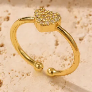 Nahaufnahme des goldenen offenen Rings mit einem funkelnden Zirkonia-Herzmotiv.
