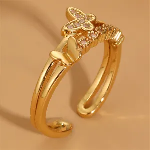 Goldener Doppelbandring mit glitzerndem Zirkonia-Schmetterling und süßen Metalldetails.