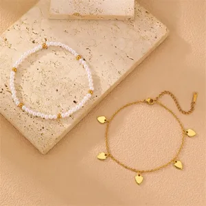 Elegantes doppeltes Fußkettchen Set mit Perlen und schönen goldenen Herzen für den Sommer.