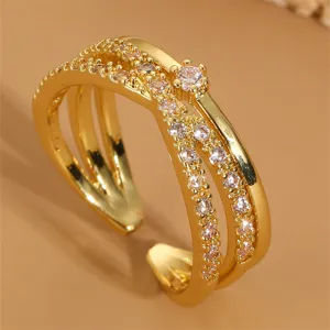 Exquisiter mehrschichtiger goldfarbener offener Ring mit funkelnden Zirkoniasteinen.