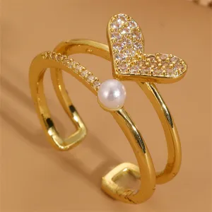 Nahaufnahme des eleganten vergoldeten Offenen Rings mit funkelndem Zirkonherz und Perle.