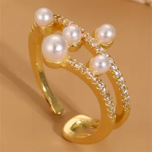 Detailaufnahme eines vergoldeten offenen Rings mit zarten Perlen und funkelnden Zirkonia.