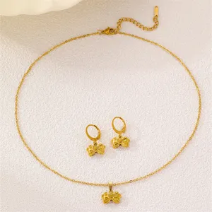Detailansicht des goldenen Edelstahl Schleife Herz Halskette und passender Ohrringe Set.