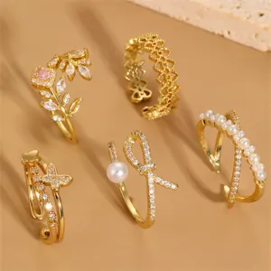 5er Set vergoldete offene Ringe mit Zirkonen, Perlen und stilvollen Schmetterling-Designs.