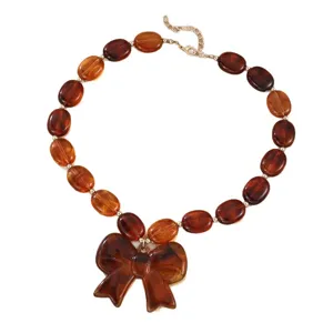 Braune Harzperlen Halskette mit grosser Schleife Anhaenger, vintage Schmuck fuer Damen.