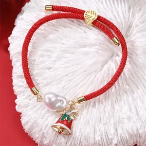 Detailansicht des roten geflochtenen Weihnachts-Armbands mit Perle und Glöckchen.