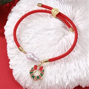 Rotes Kordelarmband mit Barockperle und Weihnachtskranz Anhänger Detailansicht des Schmucks.