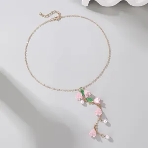 Delicate gold-tone Y necklace featuring pink lily of the valley flowers, pearls, and green leaves.