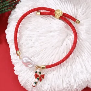 Rotes geflochtenes Weihnachtsarmband mit Perle und Zuckerstangen-Anhänger Detailaufnahme.