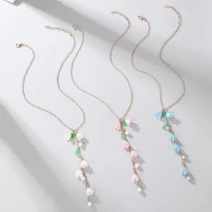 Close-up detail of the elegant lily of the valley pearl Y-necklace, showing delicate floral charms.