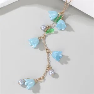 Exquisite blue lily of the valley Y-necklace detail, elegant gold chain and pearl charms.